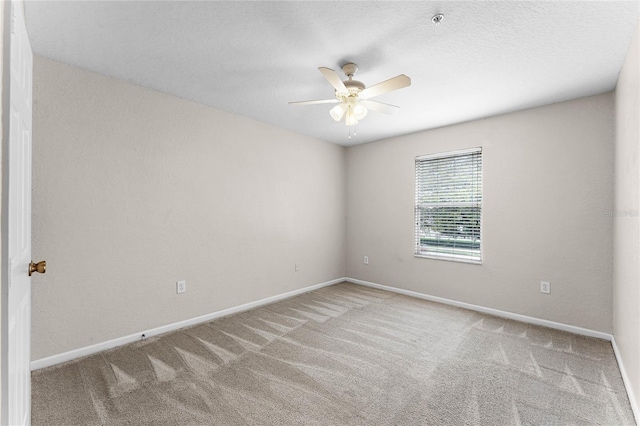 carpeted empty room featuring a ceiling fan, a textured ceiling, and baseboards