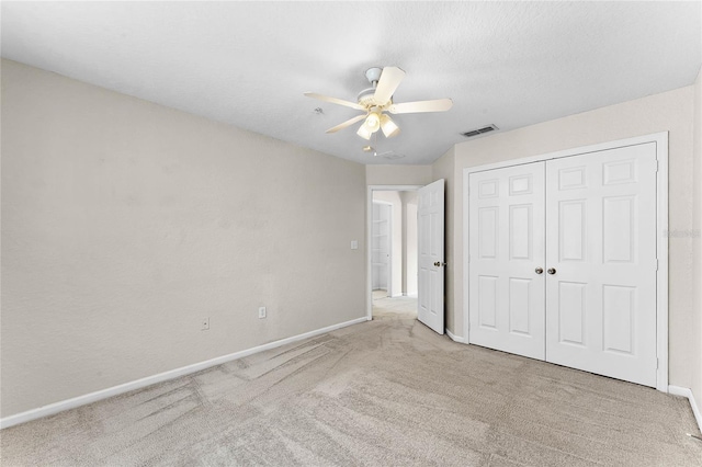 unfurnished bedroom with baseboards, visible vents, a ceiling fan, carpet floors, and a closet