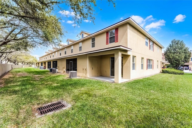 back of property with a patio, central AC unit, fence, a lawn, and stucco siding