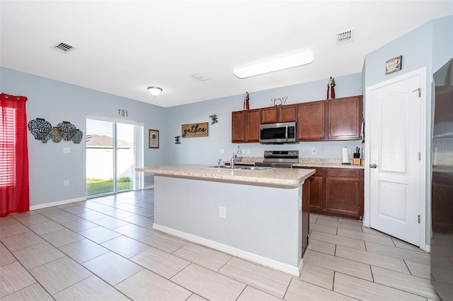 kitchen featuring visible vents, appliances with stainless steel finishes, light countertops, and a sink