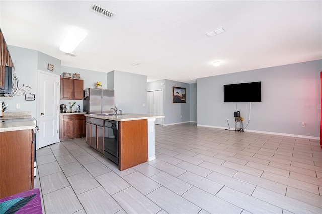 kitchen with open floor plan, light countertops, appliances with stainless steel finishes, and visible vents