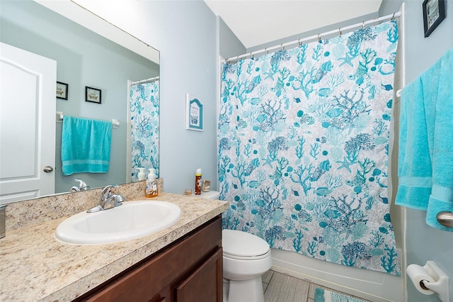 bathroom featuring toilet, shower / tub combo, and vanity