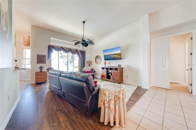 living area featuring ceiling fan, baseboards, and wood finished floors