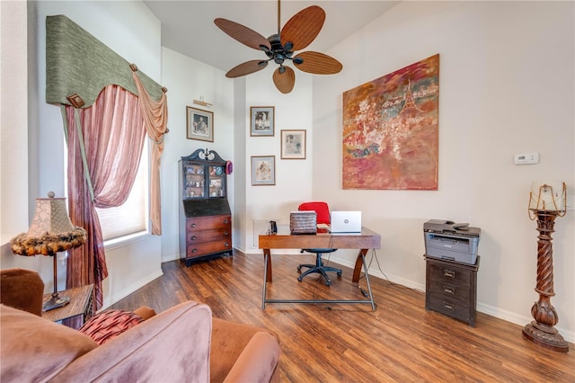 office area with wood finished floors, a ceiling fan, and baseboards