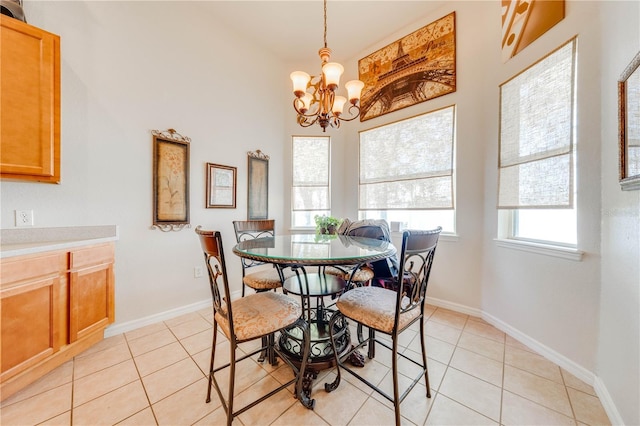 dining area featuring a chandelier, light tile patterned floors, and baseboards