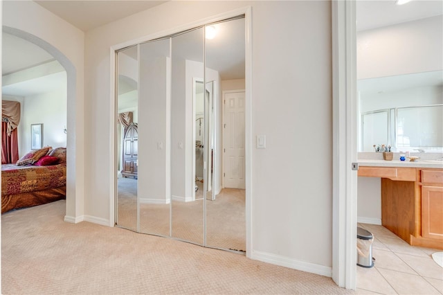 interior space with connected bathroom, vanity, and baseboards