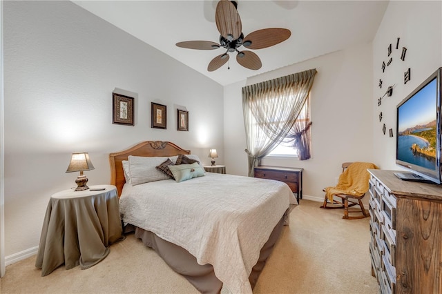 bedroom with light carpet, lofted ceiling, a ceiling fan, and baseboards