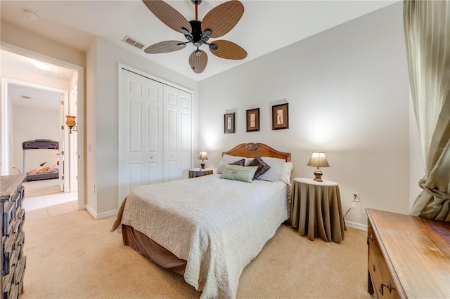 bedroom with ceiling fan, light carpet, visible vents, baseboards, and a closet