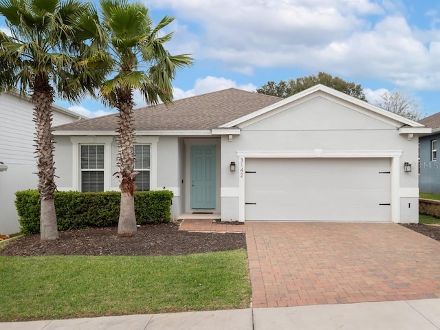 single story home with a garage, a shingled roof, decorative driveway, and stucco siding