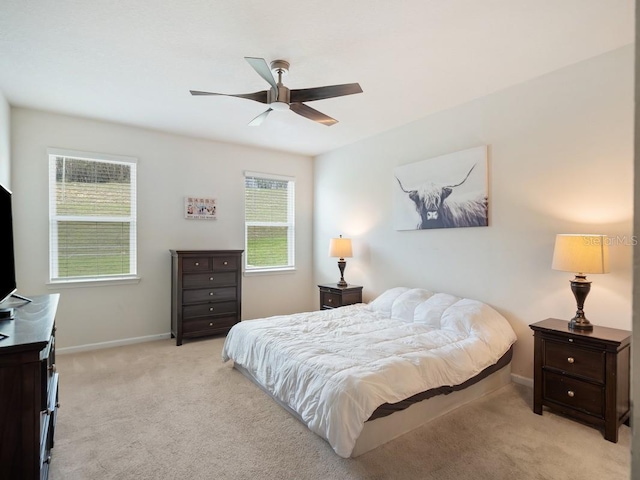 bedroom featuring baseboards, ceiling fan, and light colored carpet