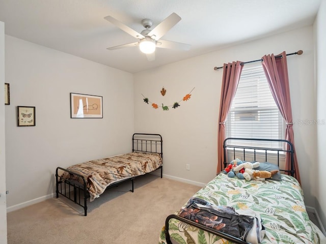 bedroom featuring light colored carpet, ceiling fan, and baseboards