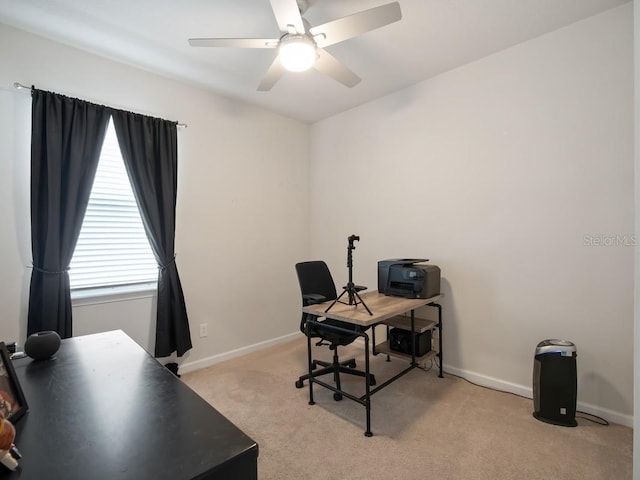 office area featuring baseboards, a ceiling fan, and light colored carpet