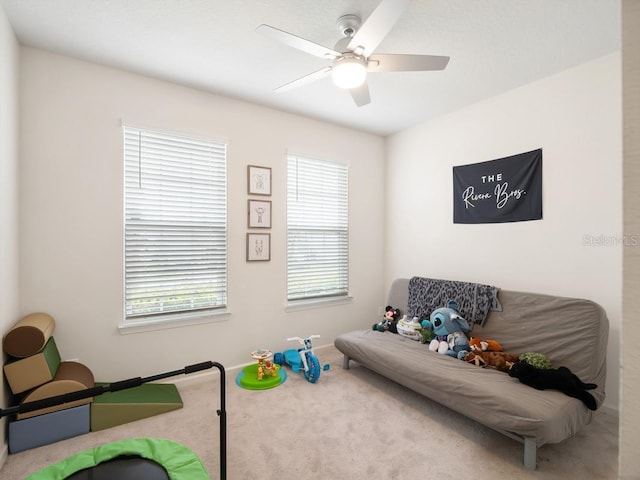 game room with carpet flooring, a ceiling fan, and baseboards