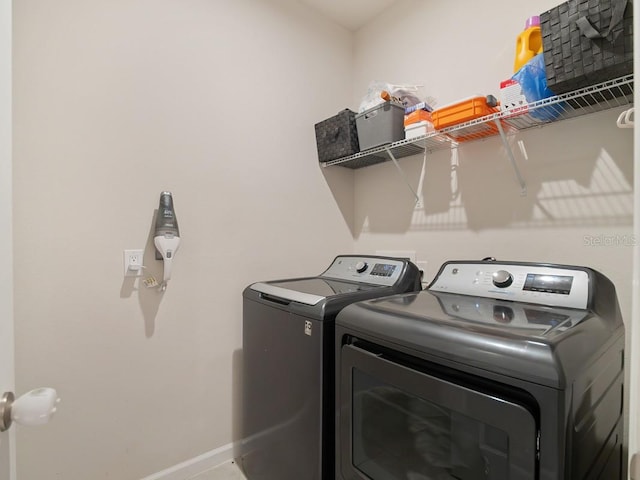 laundry room with laundry area, baseboards, and washer and dryer