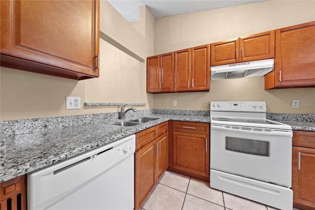 kitchen featuring under cabinet range hood, white appliances, a sink, and brown cabinets