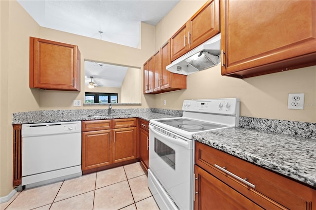kitchen featuring white appliances, under cabinet range hood, brown cabinetry, light tile patterned floors, and ceiling fan