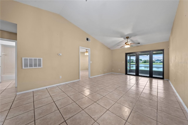 spare room with ceiling fan, lofted ceiling, light tile patterned flooring, baseboards, and a water view