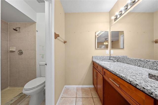 full bathroom featuring toilet, tile patterned flooring, vanity, ceiling fan, and a tile shower