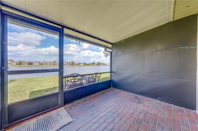 unfurnished sunroom with a water view
