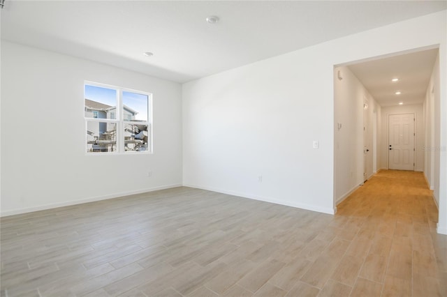 empty room featuring baseboards, recessed lighting, and light wood-style floors