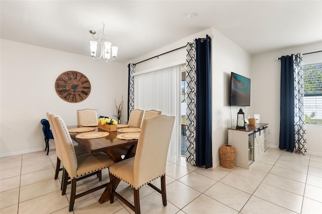 dining space featuring light tile patterned flooring, a notable chandelier, and baseboards