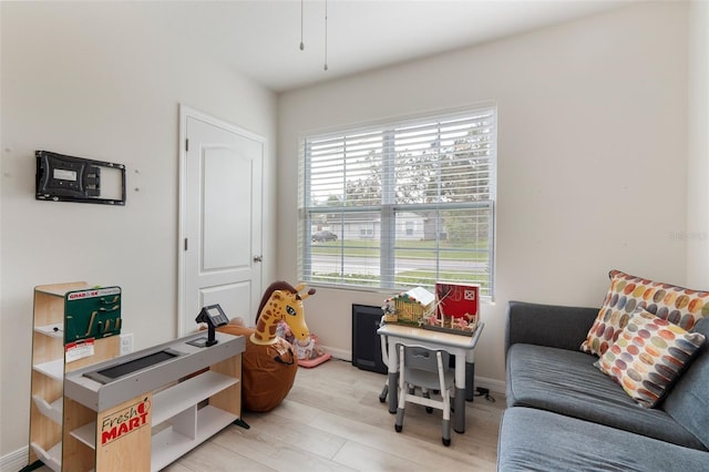 playroom featuring light wood-style flooring and baseboards