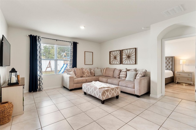 living area with visible vents, baseboards, and light tile patterned flooring