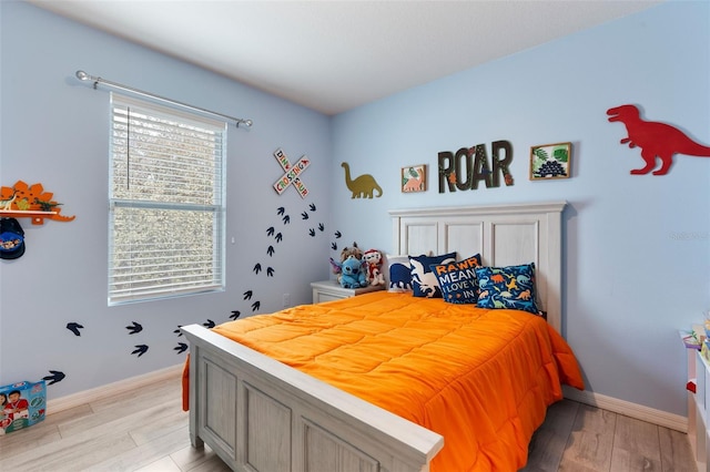 bedroom with light wood-type flooring and baseboards