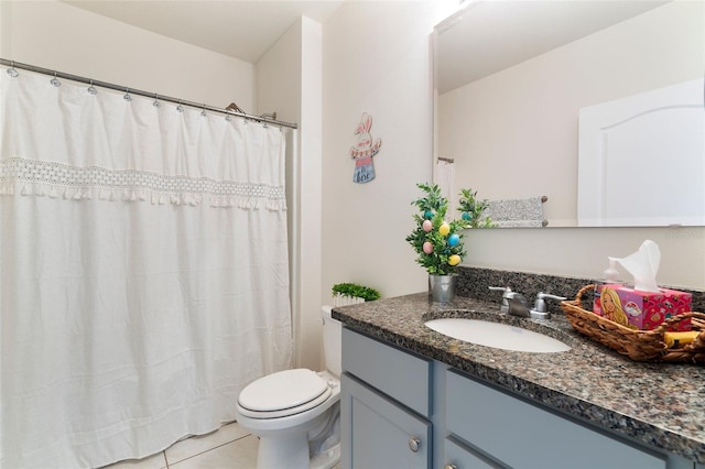 bathroom with toilet, vanity, and tile patterned floors