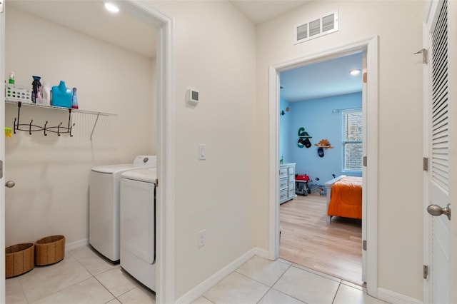 laundry room with laundry area, visible vents, washer and clothes dryer, and light tile patterned flooring