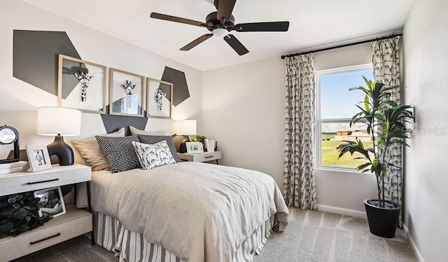 carpeted bedroom with ceiling fan and baseboards