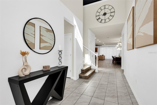 foyer with baseboards, stairway, and a notable chandelier