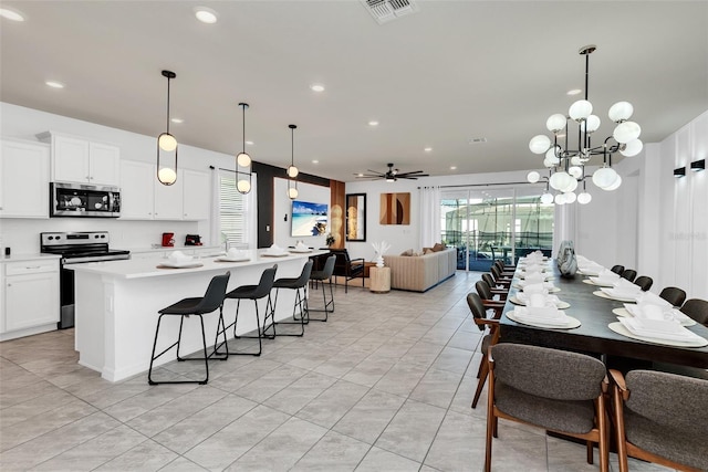 kitchen with a healthy amount of sunlight, visible vents, a kitchen island with sink, and appliances with stainless steel finishes