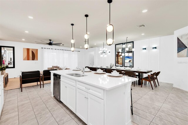 kitchen featuring a sink, visible vents, light countertops, dishwasher, and an island with sink