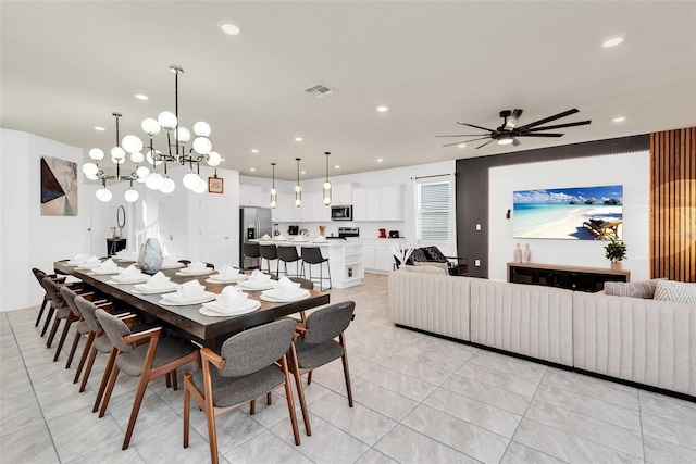 dining space with light tile patterned floors, ceiling fan with notable chandelier, visible vents, and recessed lighting