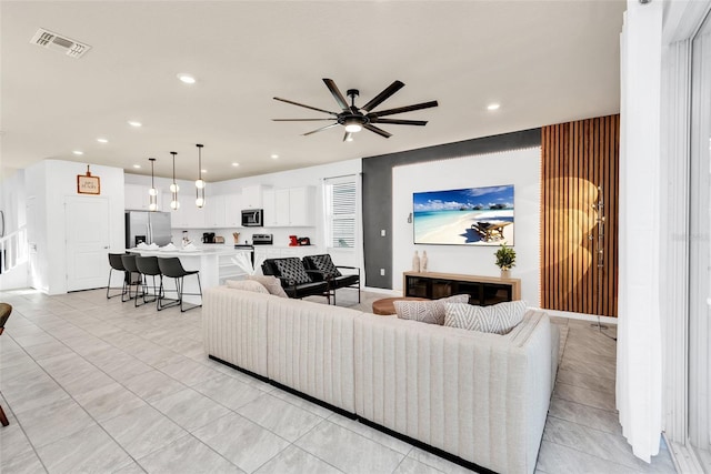 living room with ceiling fan, baseboards, visible vents, and recessed lighting