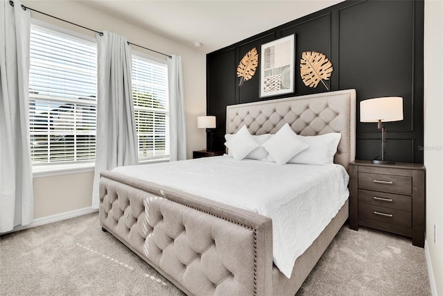 bedroom featuring baseboards and light colored carpet