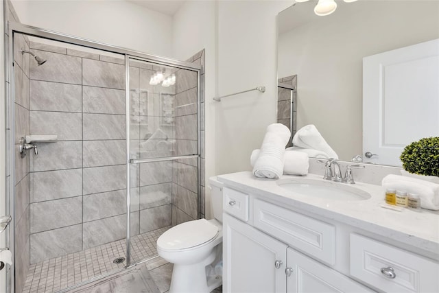 bathroom with toilet, a shower stall, and vanity