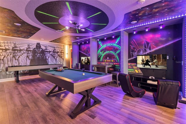 game room featuring visible vents, a raised ceiling, pool table, and hardwood / wood-style flooring