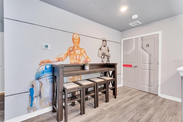 dining space featuring light wood-style floors, visible vents, and baseboards