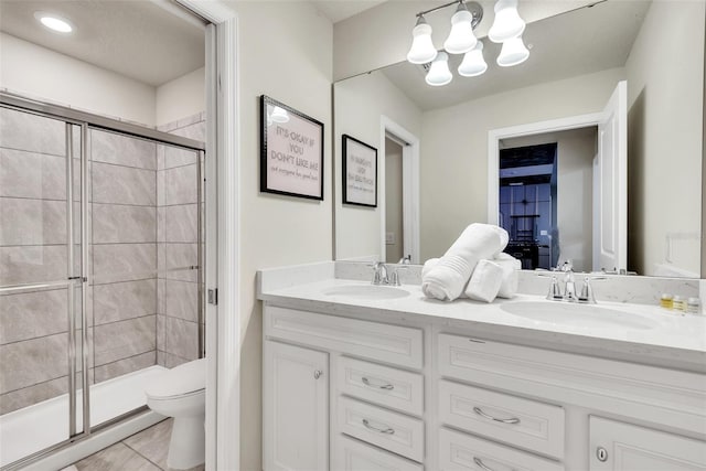 full bath with a stall shower, a sink, toilet, and a notable chandelier