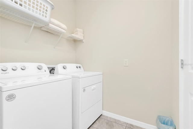 washroom featuring laundry area, light tile patterned flooring, independent washer and dryer, and baseboards