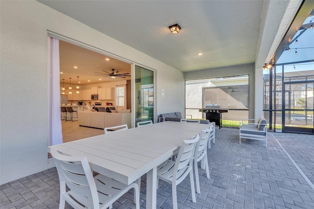 view of patio / terrace with outdoor dining space, glass enclosure, and a grill