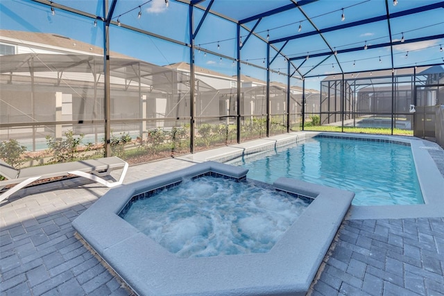 view of swimming pool featuring a patio area, a lanai, and a pool with connected hot tub