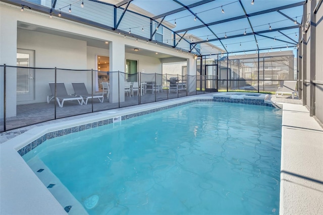 view of swimming pool with glass enclosure, a patio area, and a pool with connected hot tub