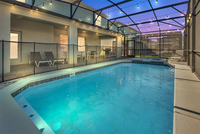 view of swimming pool featuring a patio, a lanai, and a pool with connected hot tub