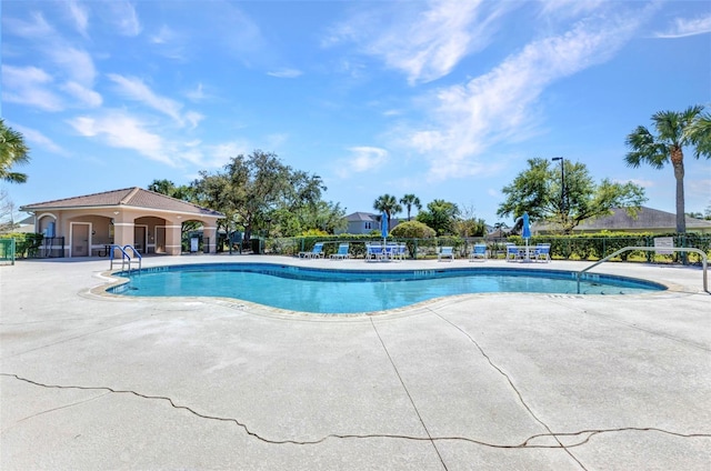 pool with a patio area and fence