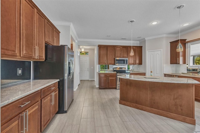 kitchen featuring light stone countertops, decorative light fixtures, stainless steel appliances, and brown cabinetry