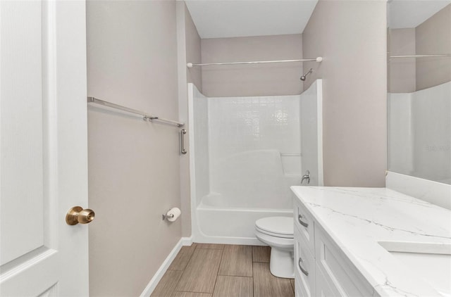 full bathroom featuring wood tiled floor, toilet, vanity, washtub / shower combination, and baseboards