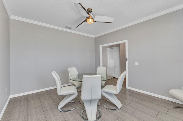 dining room with crown molding, baseboards, visible vents, a ceiling fan, and wood tiled floor